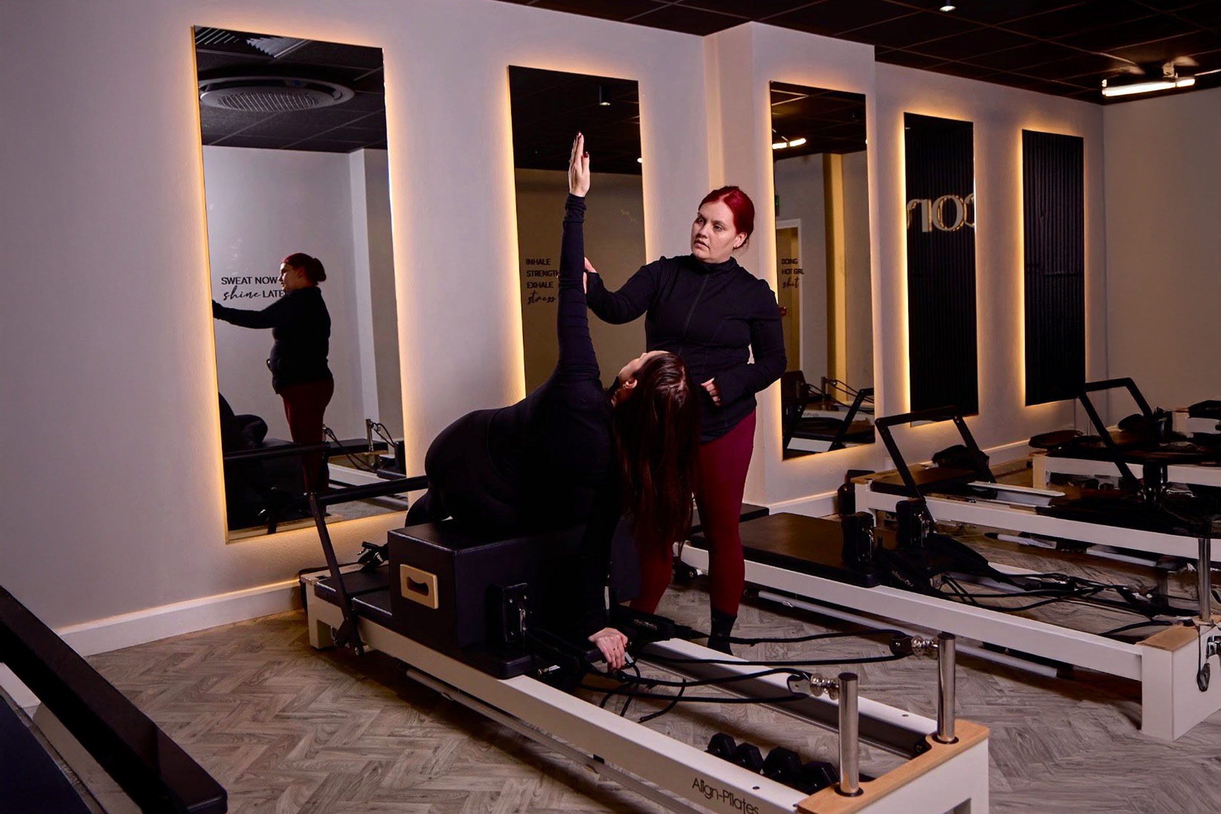 Reformer Pilates Instructor guiding a student